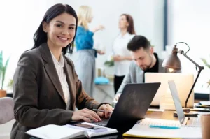 Mulher trabalhando no computador em ambiente de escritório, representando a atuação profissional na área de Administração