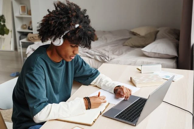 Estudante assistindo aula online no notebook durante estudo em curso EAD