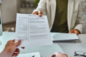 candidato entregando um currículo forte a recrutador